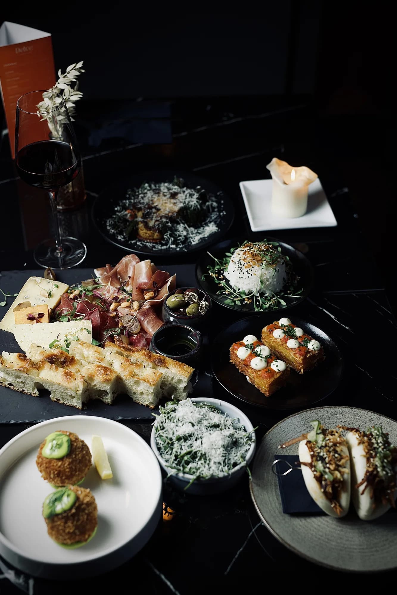 A candlelit table filled with sharing plates